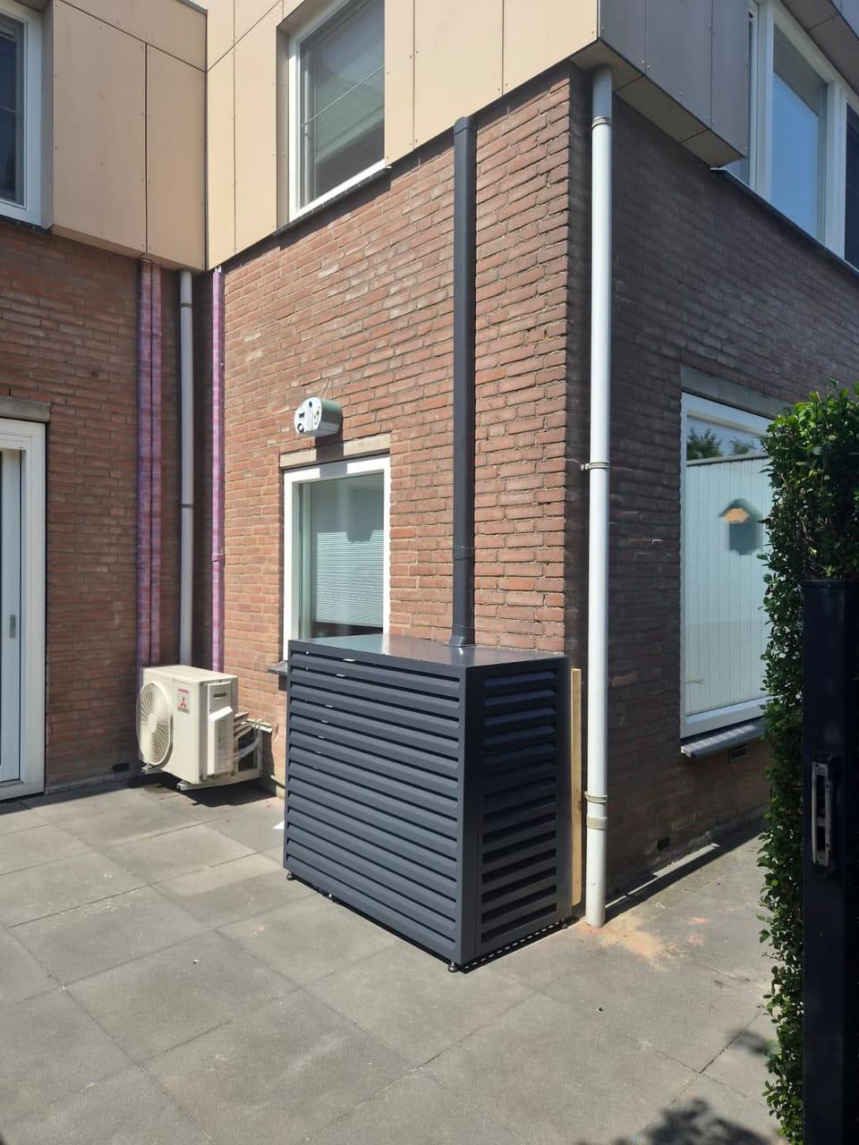 Afgeschermde warmtepomp-buitenunit bij een woning in Almere